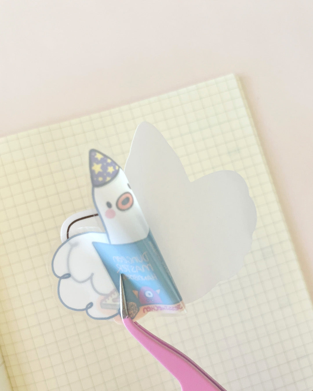Die-cut DND Roomba sticker being peeled with tweezers