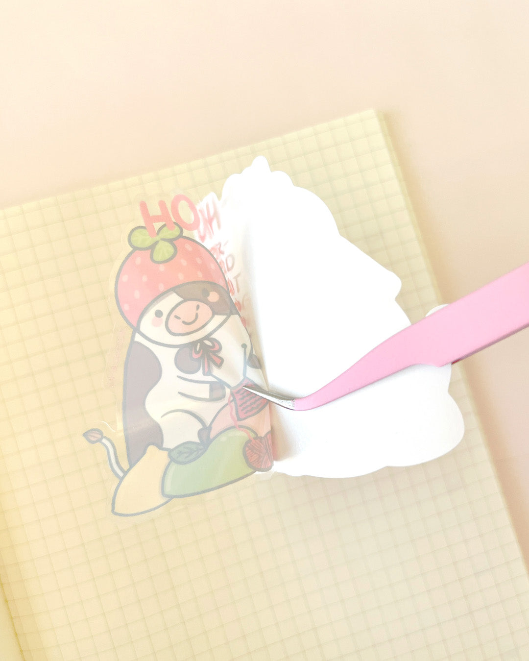 Die-cut cow sticker being placed with tweezers