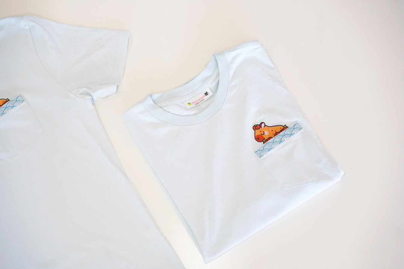 Light blue t-shirts with capybara pocket detail