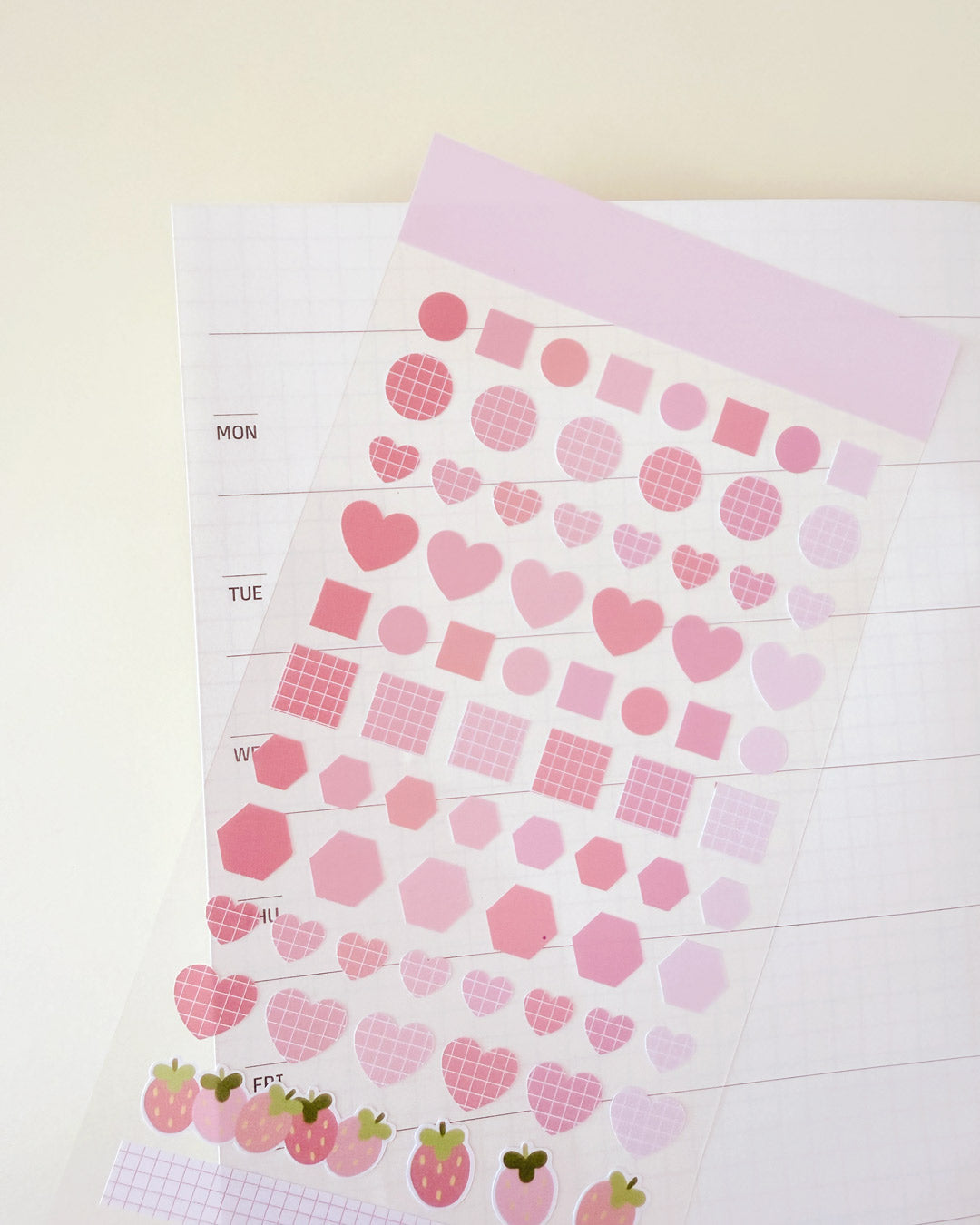 Pink sticker sheet with hearts, circles, and squares.